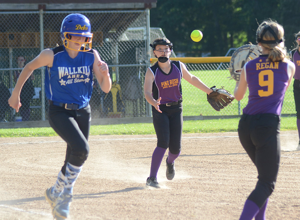 Pine Bush-Monticello pitcher Avery Ogden flips the ball to first baseman Kaileigh Regan as Wallkill Area’s Ava O’Flaherty runs to first base during Wednesday’s District 19 Majors softball tournament game.